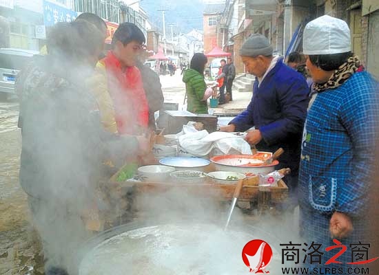 在熱氣騰騰的鍋邊，買羊肉套的食客排起了隊(duì)。