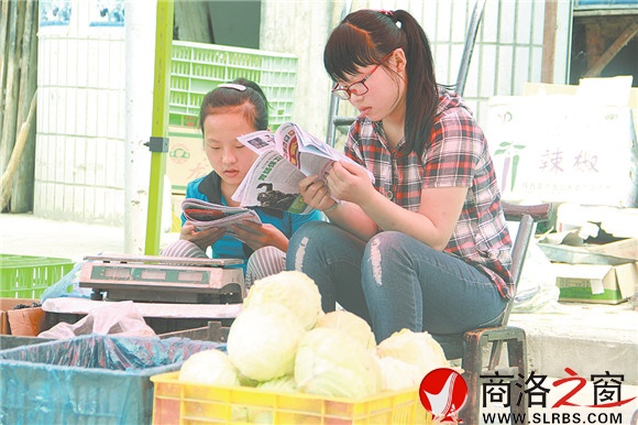 商州區(qū)楊斜鎮(zhèn)集市上，南思佳和妹妹在幫父母賣菜，閑暇之余，她們會拿起課外讀物翻一翻。在這個假期里，她們呆的最多的地方就是這個菜攤。
